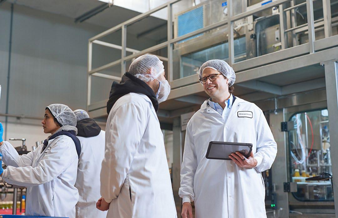 Deux personnes debout dans une usine de fabrication de jus.